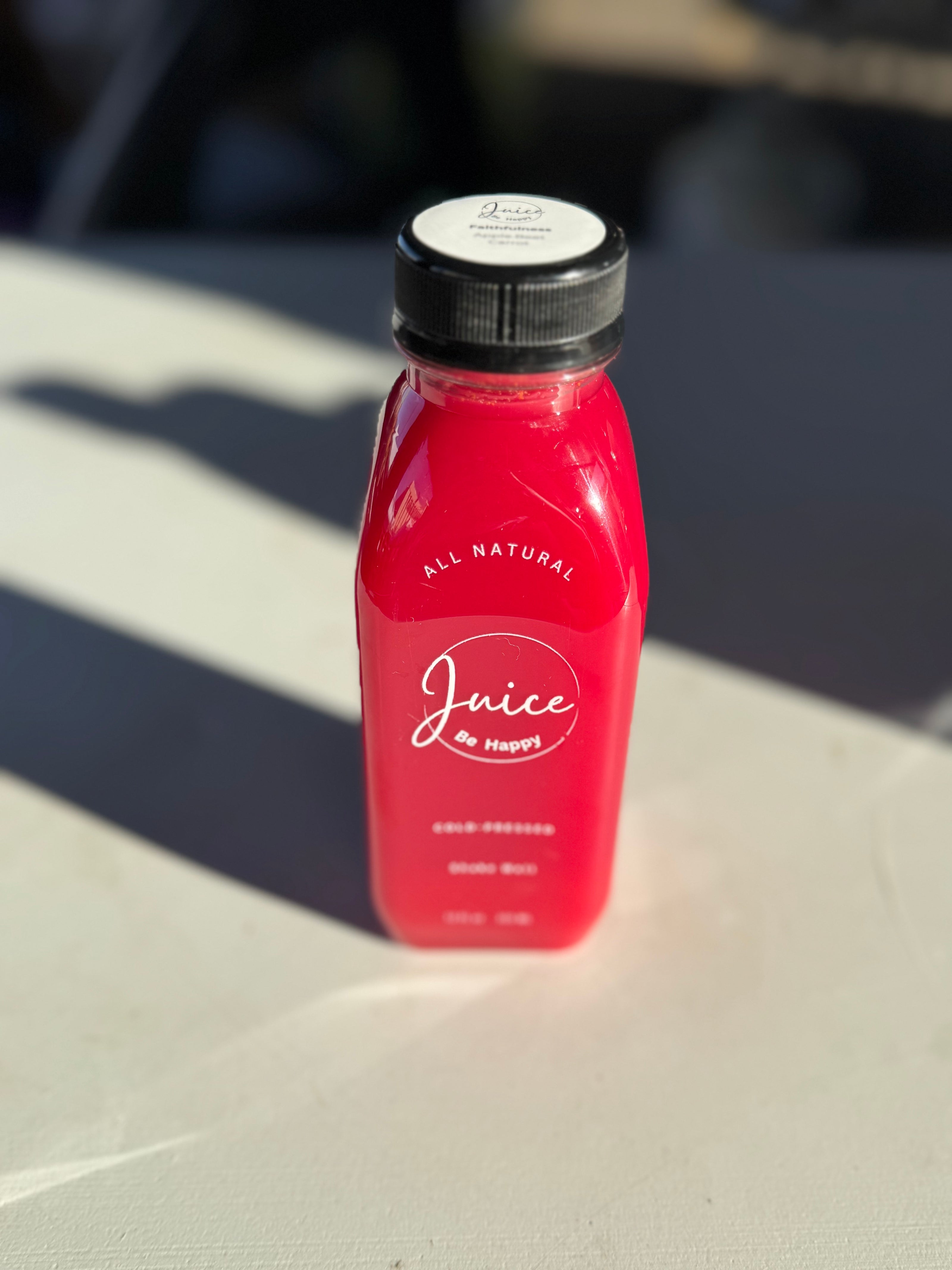 Juice Be Happy Faithfulness blend cold pressed carrot, apple, beet, and lemon juice in a glass bottle for vision and overall wellness.